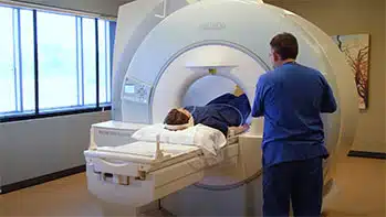Tech and patient in a high field MRI machine.
