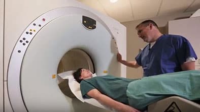 Tech performing PET/CT on patient