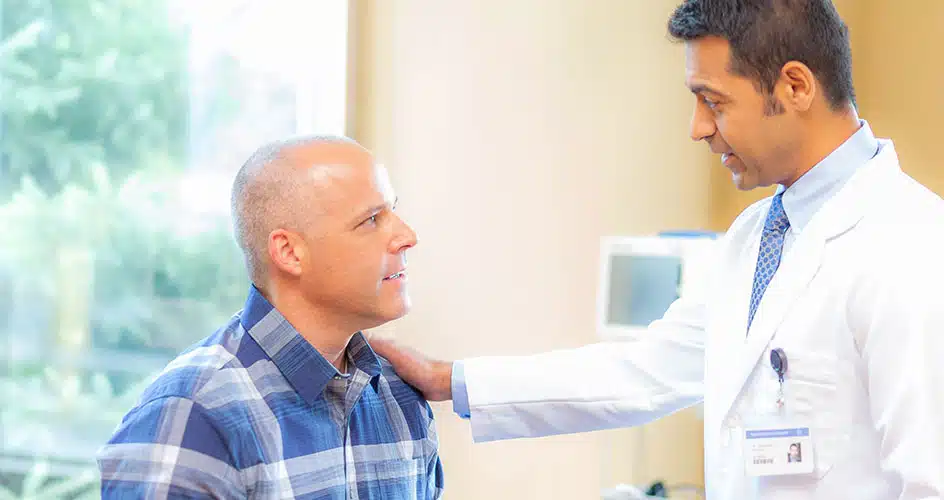 male doctor comforting male patient