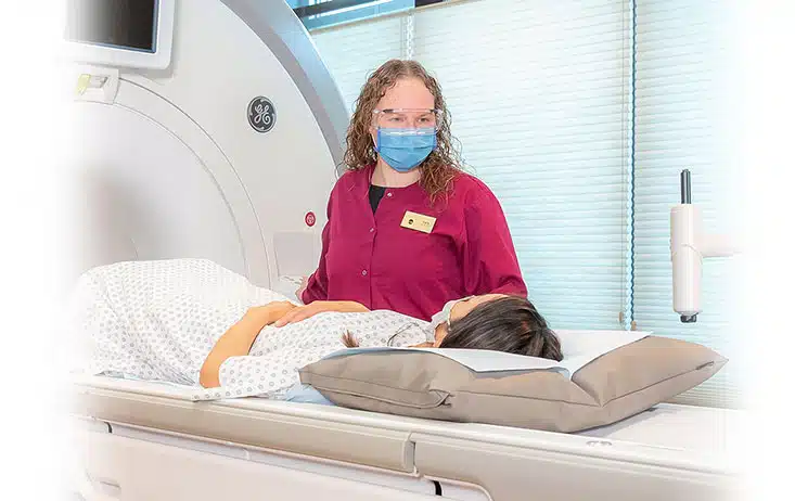 technologist helping patient into mri scanner