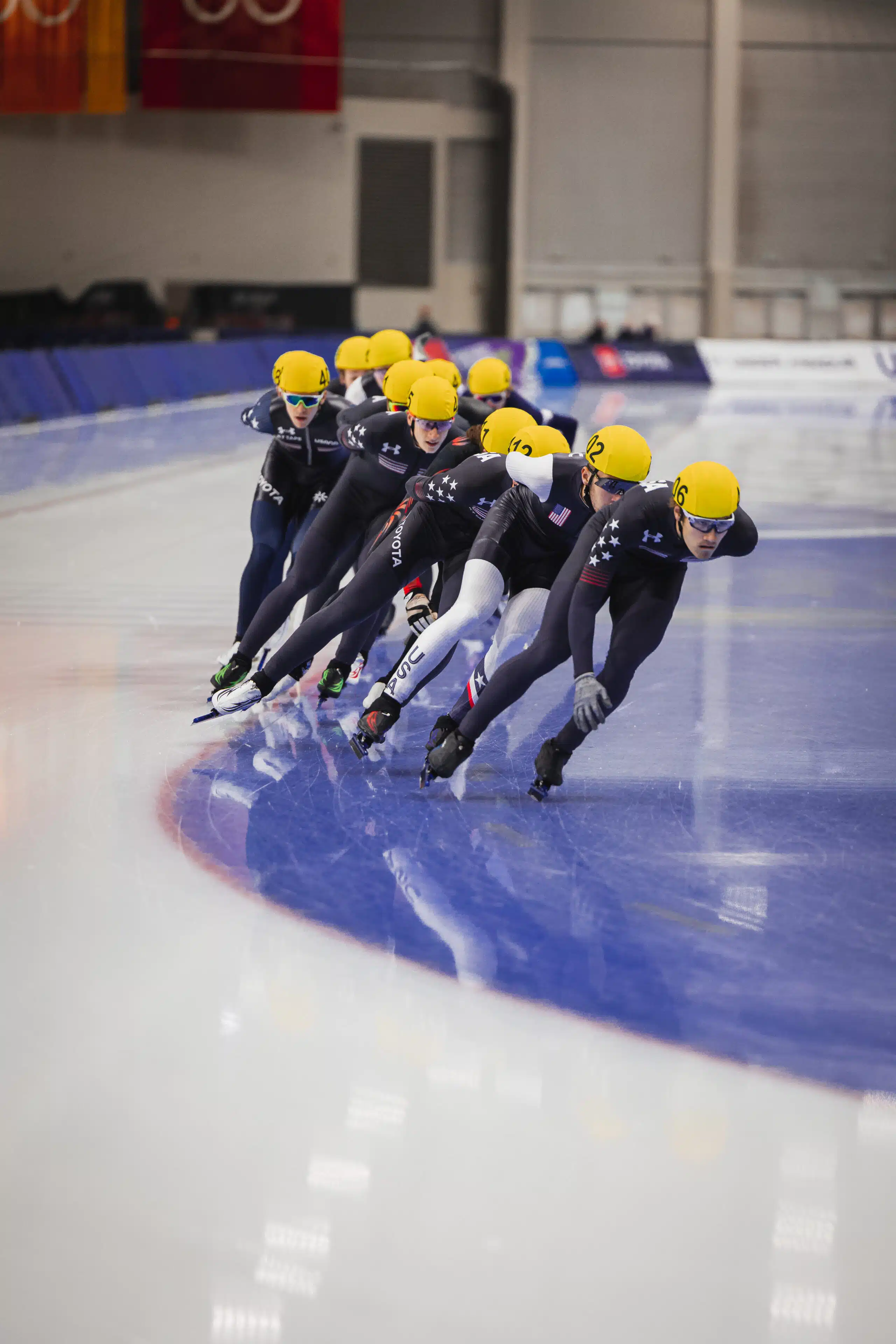 speedskating on ice yellow helmets black suits