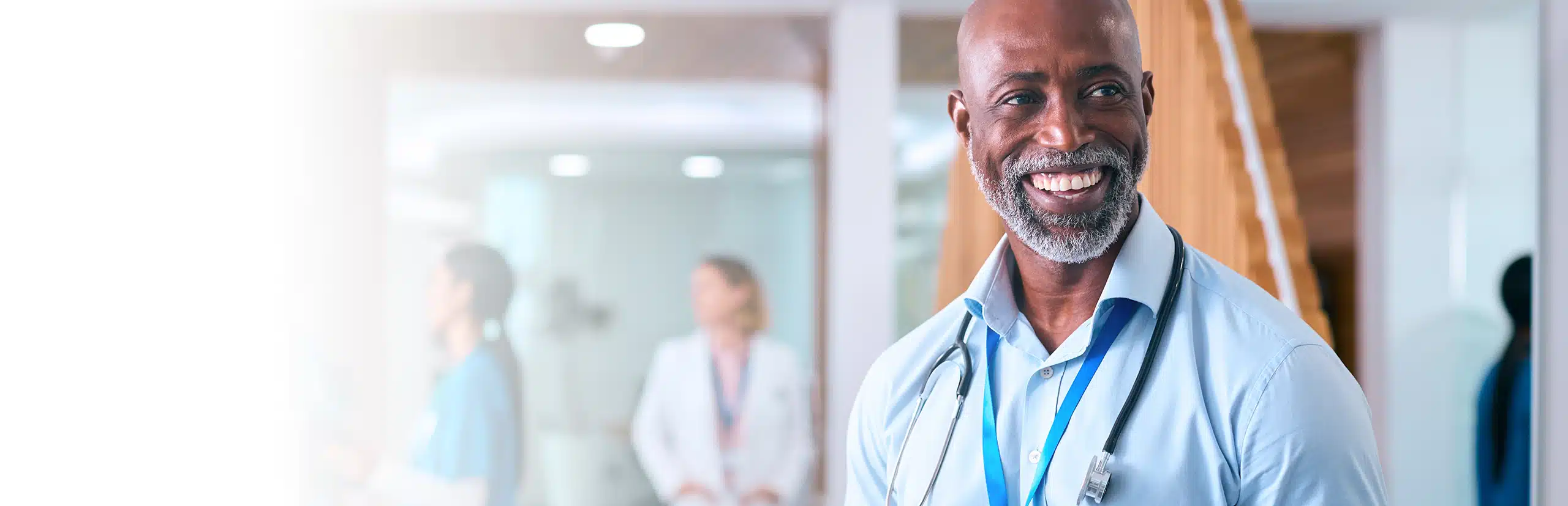 man in blue button down and blue lanyard smiling