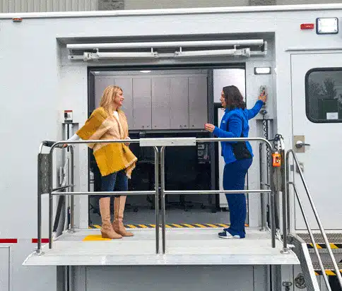 Two women speak to each other on a loading platform